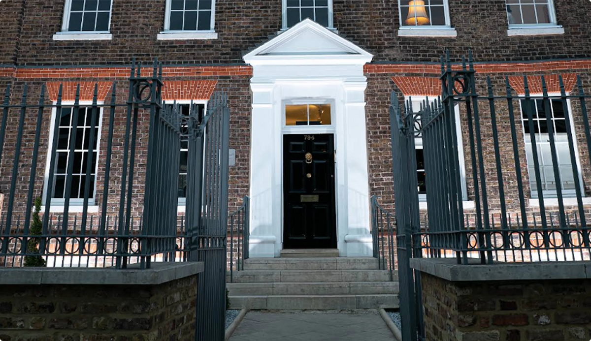 Brick building with a black door and iron gate