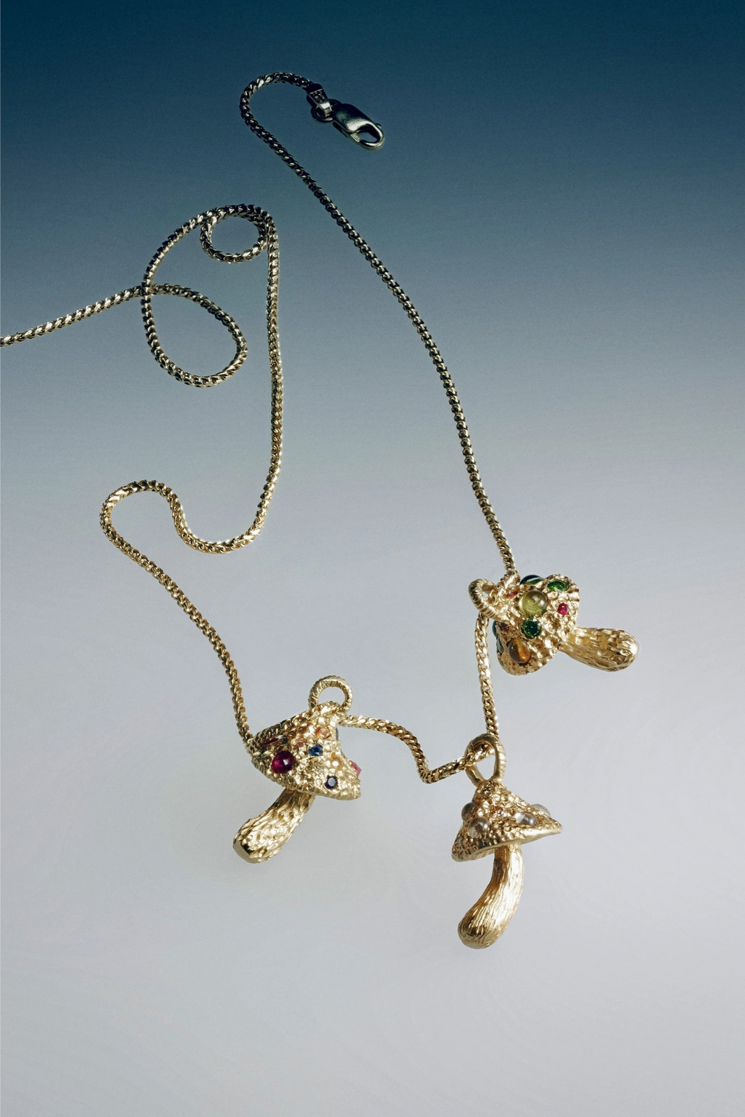 Gold necklace with shoe pendants on a gradient background